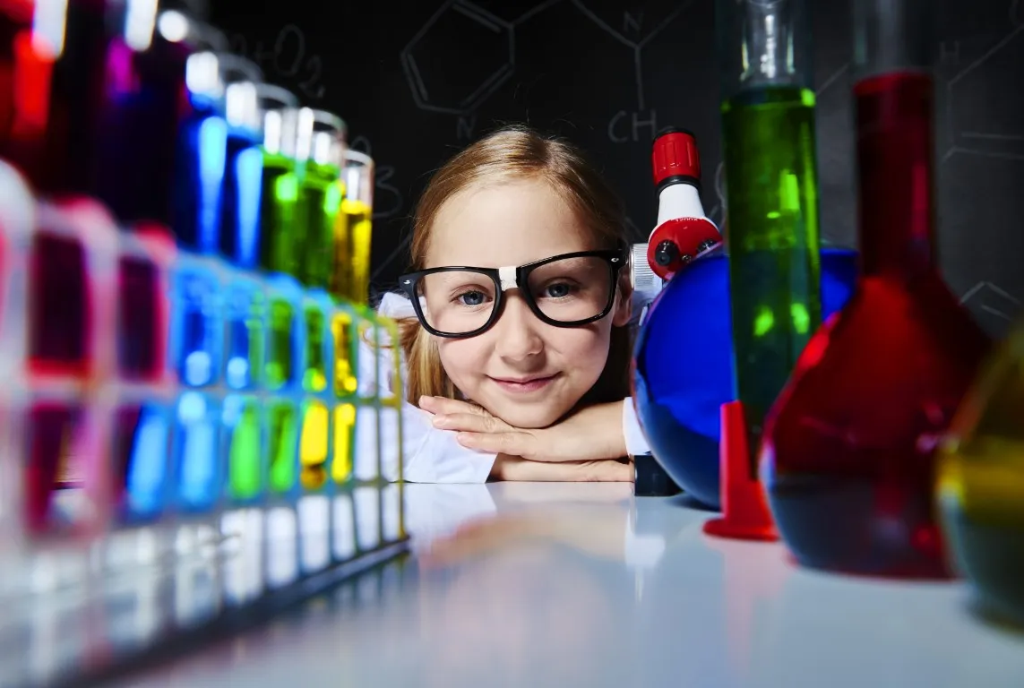 kurs do matury z chemii: dziewczyna pracuje między naczyniami chemicznymi w laboratorium