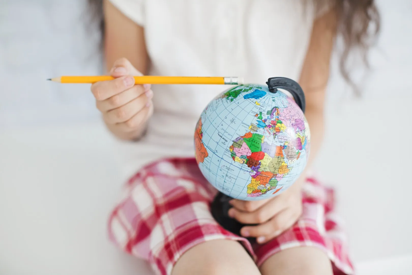 matura rozszerzona z geografii 2027 – dziewczyna trzyma globus ziemi na kolanach