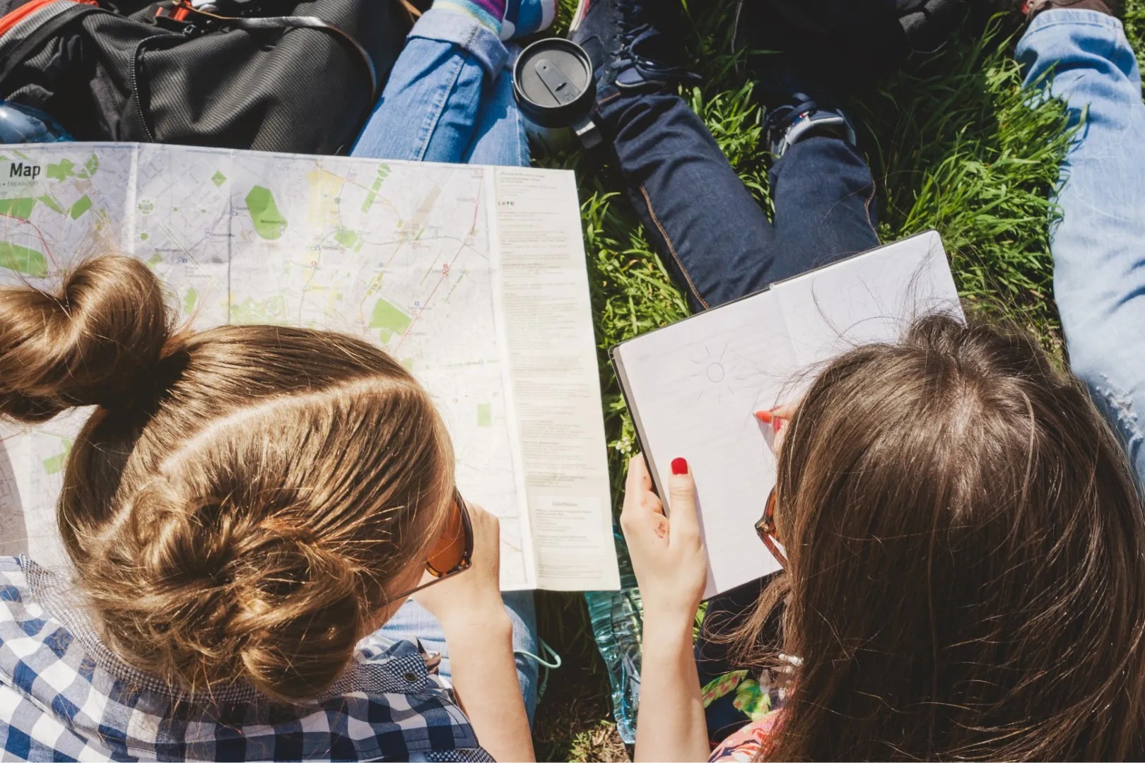 geografia fizyczna i społeczno-ekonomiczna na maturze – dwie uczennice analizują mapę w parku przygotowując się do egzaminu